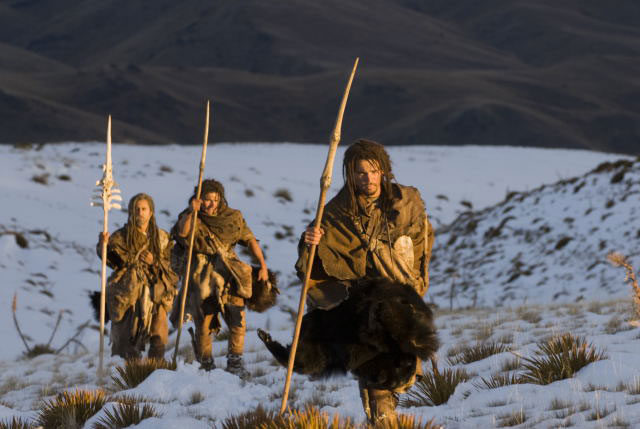 tres cazadores de la prehistoria con sus lanzas y atuendos de piel
