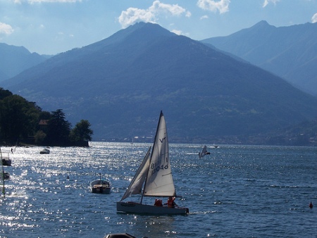Lago Como (Italia). Montaña al fondo, lago en primer plano y un pequeño barco de vela