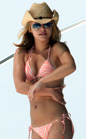 Jessica Simpson con bikini naranja, gafas de sol y sombrero